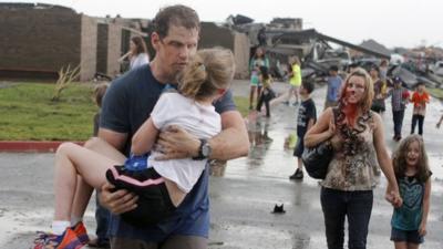 The Cobb family walk away from the tornado aftermath in Oklahoma