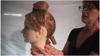 Janet Stephens looks at a hairstyle on a mannequin