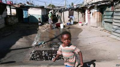 A child runs around in the washing area as her mother does her washing in Johannesburg Alexandra township (archive shot)