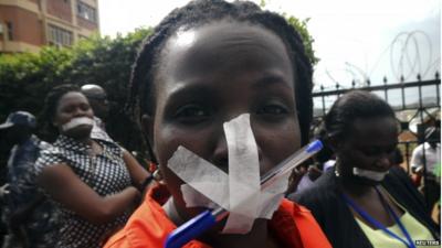 An employee of the Daily Monitor newspaper with her mouth taped shut