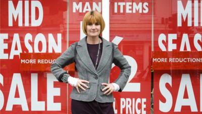 Mary Portas stands outside a shop with sale signs