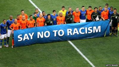 Footballers hold a 'Say No to Racism' banner