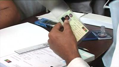 A voter registration card being laminated