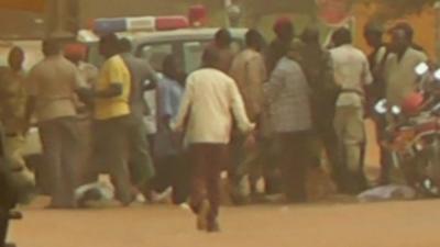 People stand near police car in Niger