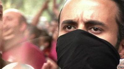 Protester with scarf over his face