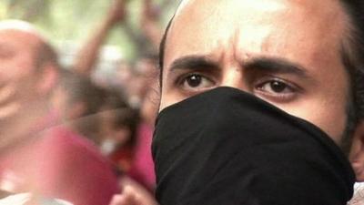 Protester with scarf over his face