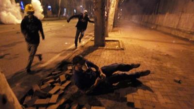 A protester falls down as others run to avoid tear gas during the third day of nationwide anti-government protest near the Prime Minister's office at Besiktas area in Istanbul,