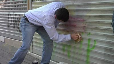 Man scrubs graffiti from street in Istanbul