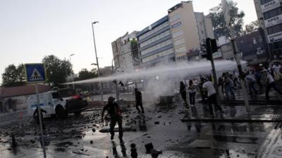 Riot police use a water cannon to disperse anti-government protesters