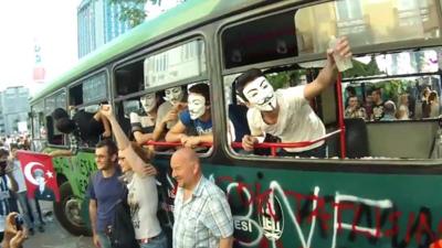 Demonstrators on a destroyed bus