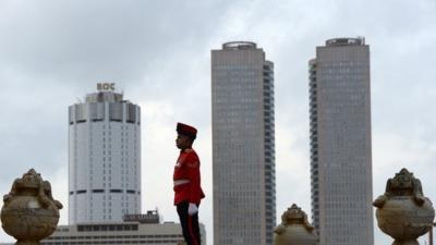 Sri Lankan Army soldiers stand at attention near the Sri Lanka"s national flag as it is lowered as part of a daily ceremony at Galle Face Green, a promenade in Colombo on June 4, 2013