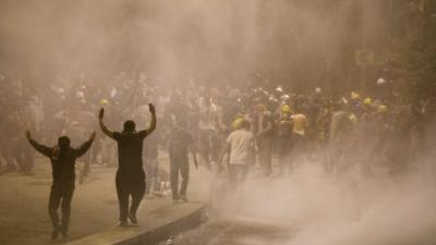 Protestors run as they are hit by a police water cannon during clashes near Turkish prime minister Recep Tayyip Erdogan office