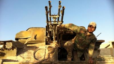 A Syrian army soldier exits his tank