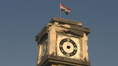 The Syrian flag and a picture of President Assad flies on top of Qusayr's clock tower