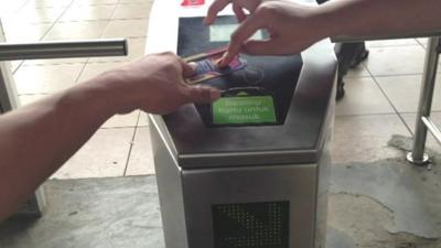 A new electronic card and gate system in a Jakarta train station