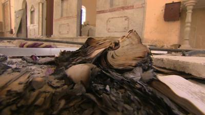 Burned book inside St. Elias church, Qusair, Syria