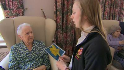 A student reading poetry to a woman with dementia