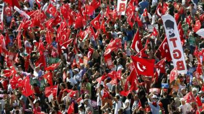 Anti-government protesters wave flags during a rally in Istanbul's Taksim square