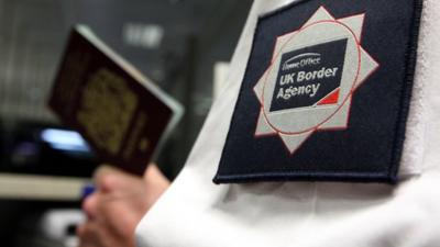 UK Border Agency official inspects a British passport