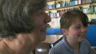 Girl shows grand-mother how to use a PC