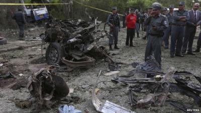 Afghan policemen inspect the site of a suicide car bomb attack in Kabul