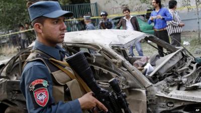 An Afghan Police man stands guard at the scene of a suicide car bomber attack that struck outside the Afghan Supreme Court in Kabul