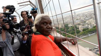 Artist Lena Nyadbi visits the Eiffel Tower during the inauguration of her giant art work