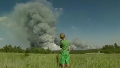 Boy watches plumes of smoke
