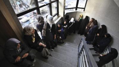 Iranian women queue in a polling station to vote