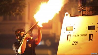 A riot policeman fires teargas during an anti-government protest in Istanbul