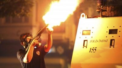 A riot policeman fires teargas during an anti-government protest in Istanbul