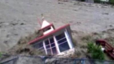 A building falling into flood water