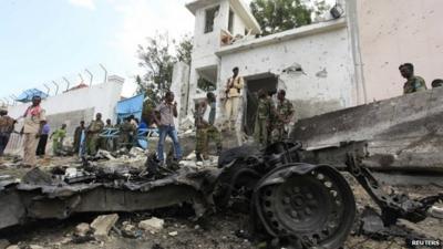 Security agents stand near the scene of a suicide bomb attack outside the United Nations compound in Somalia"s capital Mogadishu