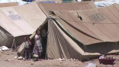 Refugee children outside a tent