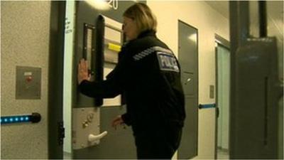 A police woman closing a cell door