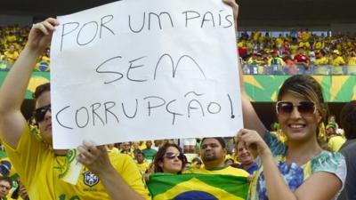 Brazilian football fans show a poster reading "For a Country Without Corruption"