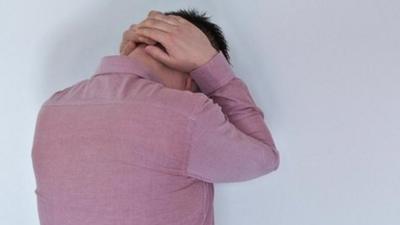 Man holding his hands behind his head