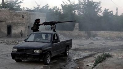 A Syrian rebel fires a heavy machine gun