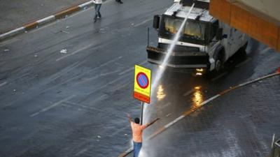 Water cannon is fired at a protester