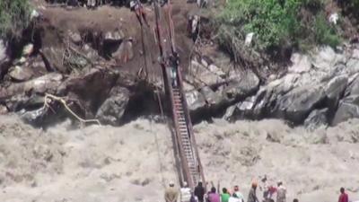 People cross water on bridge