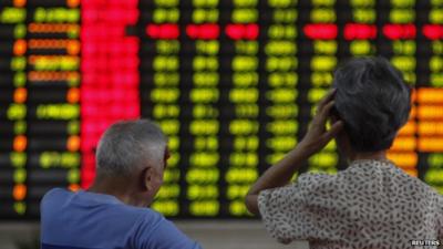 Elderly couple in front of stock market boards