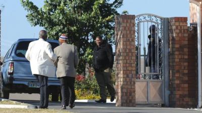 Pedestrians and a vehicle are seen at the entrance to the home of former president Nelson Mandela in Qunu, South Africa