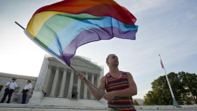 Gay rights advocate waves a rainbow flag in front of the Supreme Court on 26 June 2013 in Washington DC