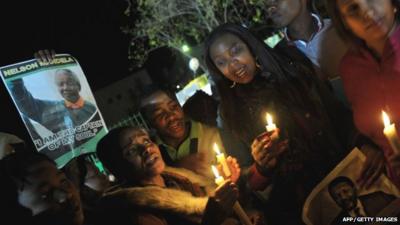 Well-wishers hold candles and photos of Nelson Mandela outside the Mediclinic heart hospital in Pretoria