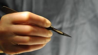 A surgeon holding a scalpel