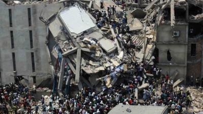 People rescue garment workers trapped under rubble at the Rana Plaza building after it collapsed