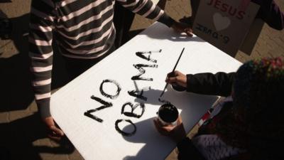 Anti-American demonstrators paint signs before marching through the streets to protest against the official visit of U.S. President Barack Obama