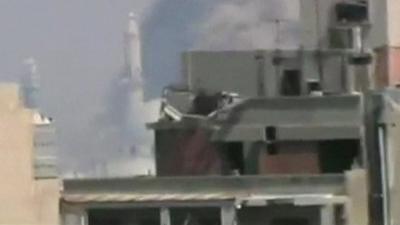 Still from unverified amateur footage purportedly shows smoke rising from a thirteenth century mosque hit by shells in Homs