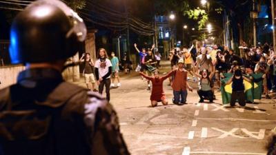 A riot squad officer in Rio de Janeiro faces protestors