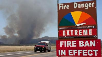 A fire engine passes by a fire ban sign as the Yarnell Hill Fire advances on Peeples Valley, Arizona